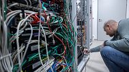 An IT specialist monitoring the servers that manage the hospital's machines.