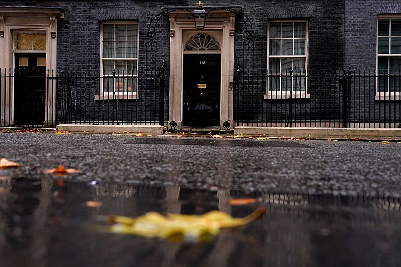 Rain and fallen leaves create an autumn atmosphere at 10 Downing Street in London, 20 October, 2022