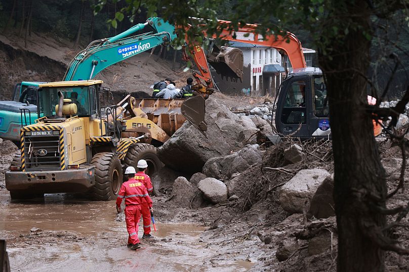 Rescuers work to restore a road damaged by mountain torrents following a heavy downpour in Yuzhong County, 8 August, 2025