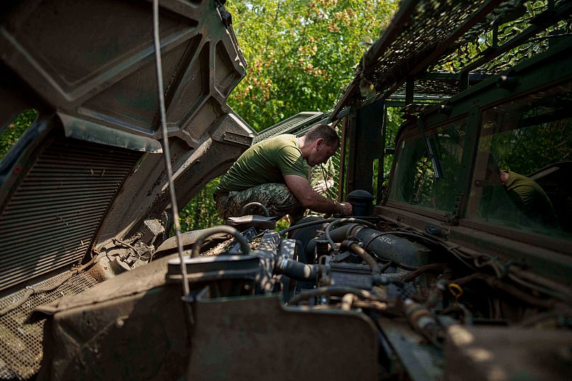 A Ukrainian serviceman of the 148th artillery brigade repairs a vehicle near the frontline in Zaporizhzhia region, 7 August, 2025