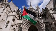 A demonstrator waves a Palestinian flag outside the High Court in London, 21 July 2025