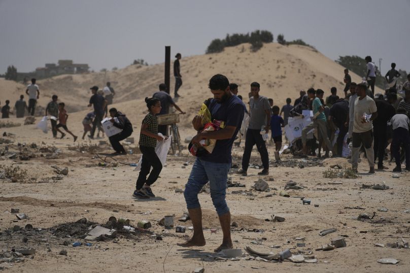 فلسطينيون يجمعون مساعدات إنسانية من الإمارات بعد إسقاطها جوًا في دير البلح وسط قطاع غزة، السبت 9 أغسطس 2025.