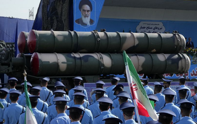 Sistema de defesa aérea S-300 de fabricação russa é transportado num camião em frente a um retrato do falecido fundador revolucionário iraniano Ayatollah Khomeini