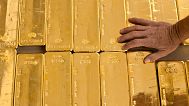 a person touches gold bars in the gold store of the Cantonal Bank of Zurich