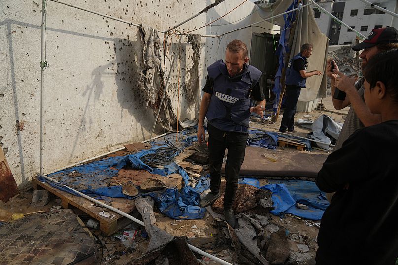 Palestinians inspect the destroyed tent where journalists were killed by an Israeli airstrike in Gaza City, 11 August, 2025