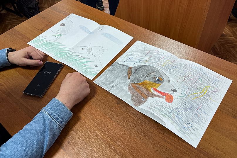 Moskalyov's lawyer Vladimir Biliyenko shows drawings that Maria Moskalyova, daughter of Alexey Moskalyov, drew for her father in a courtroom in Yefremov, 27 March 2023