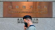 A man walks past the entrance of the headquarters of China Evergrande Group in Hong Kong Monday, Oct. 4, 2021.