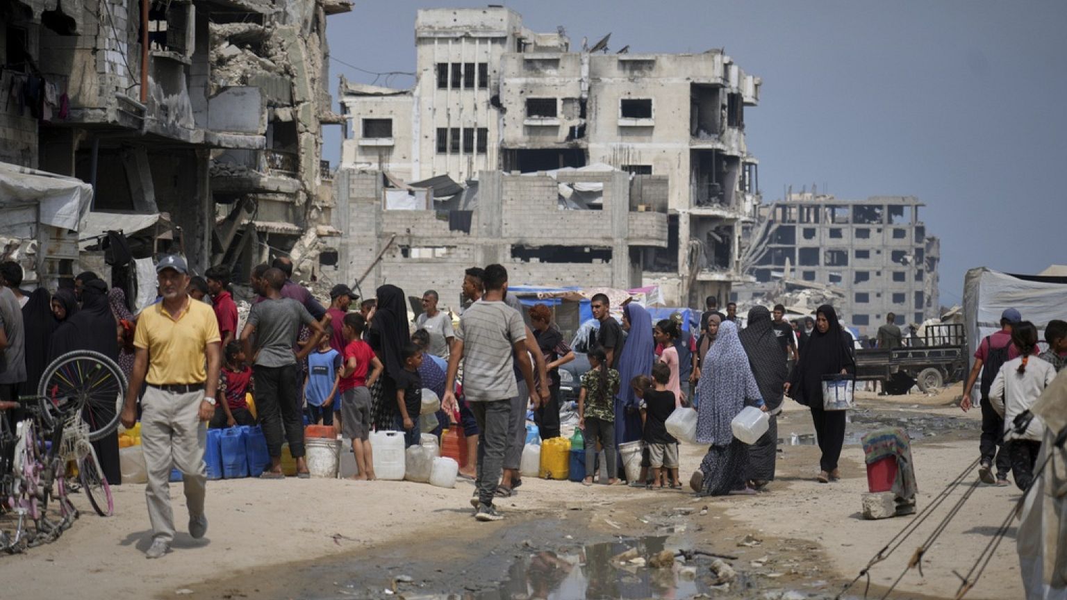 في حرارة الصيف، يصطف الفلسطينيون للحصول على المياه من نقطة توزيع في مدينة غزة