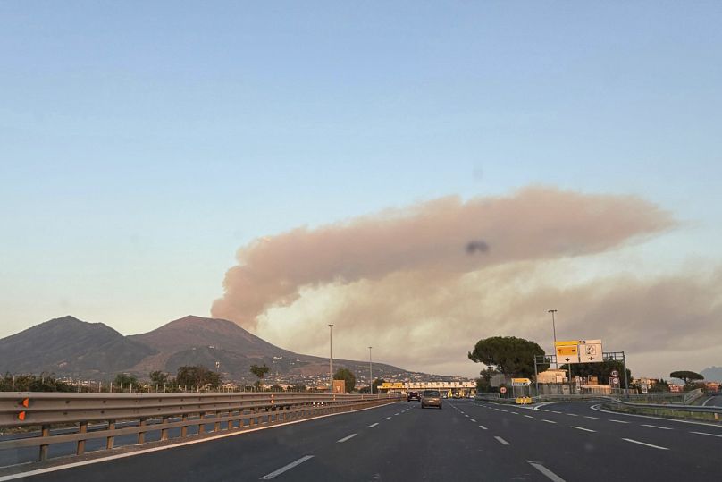 De la fumée s'élève derrière le volcan Vésuve à la suite d'un incendie dans le parc national près de Naples, en Italie, le dimanche 10 août 2025.