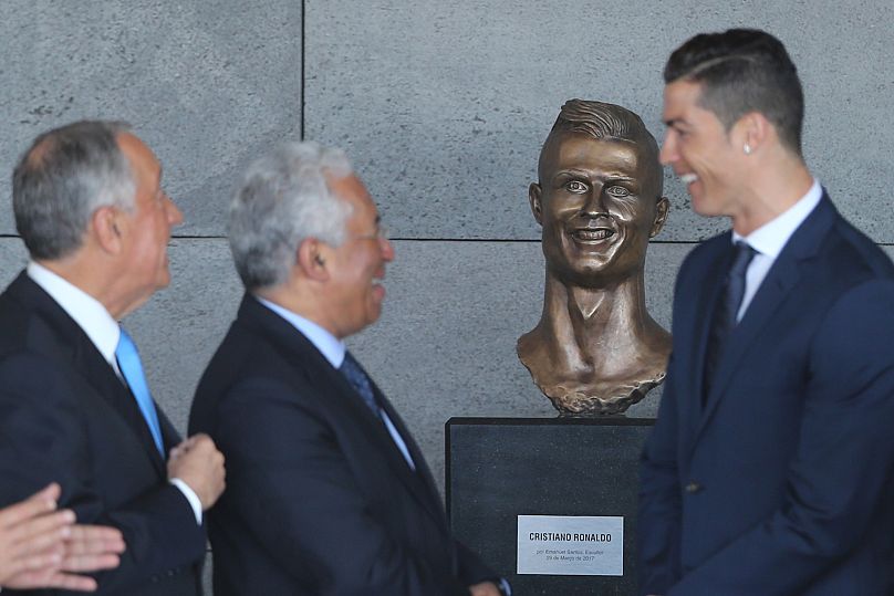 Portuguese President Marcelo Rebelo de Sousa, Prime Minister Antonio Costa, and Cristiano Ronaldo beside a bust of the player at Madeira Airport.