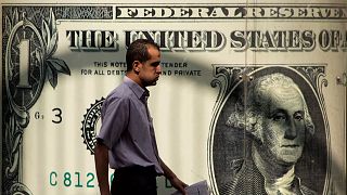 An Egyptian man walks past a poster showing a U.S. dollar outside an exchange office in Cairo, Egypt. November 2016. 
