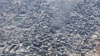 Smoke rises from Gaza City as seen from a Jordanian Air Force C-130 plane during an airdrop of humanitarian aid for Palestinians, 7 August, 2025