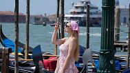Una turista toma una fotografía con su 'smartphone' en Venecia, Italia, el 25 de junio de 2025.
