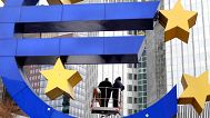 Workers change tube lights of the Euro sculpture in front of the European Central Bank in Frankfurt,