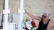 FILE: A woman touches the photo at the grave of her relative, killed in the 1974 Turkish invasion of Cyprus, in Nicosia, 20 July 2024