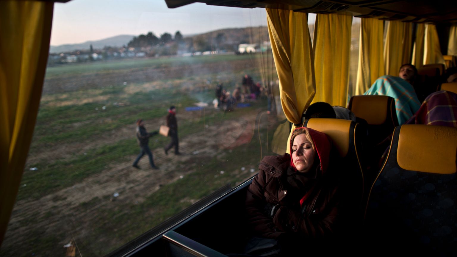 ARQUIVO: Uma refugiada afegã dorme num autocarro na fronteira entre a Grécia e a Macedónia, em Idomeni, a 5 de dezembro de 2015
