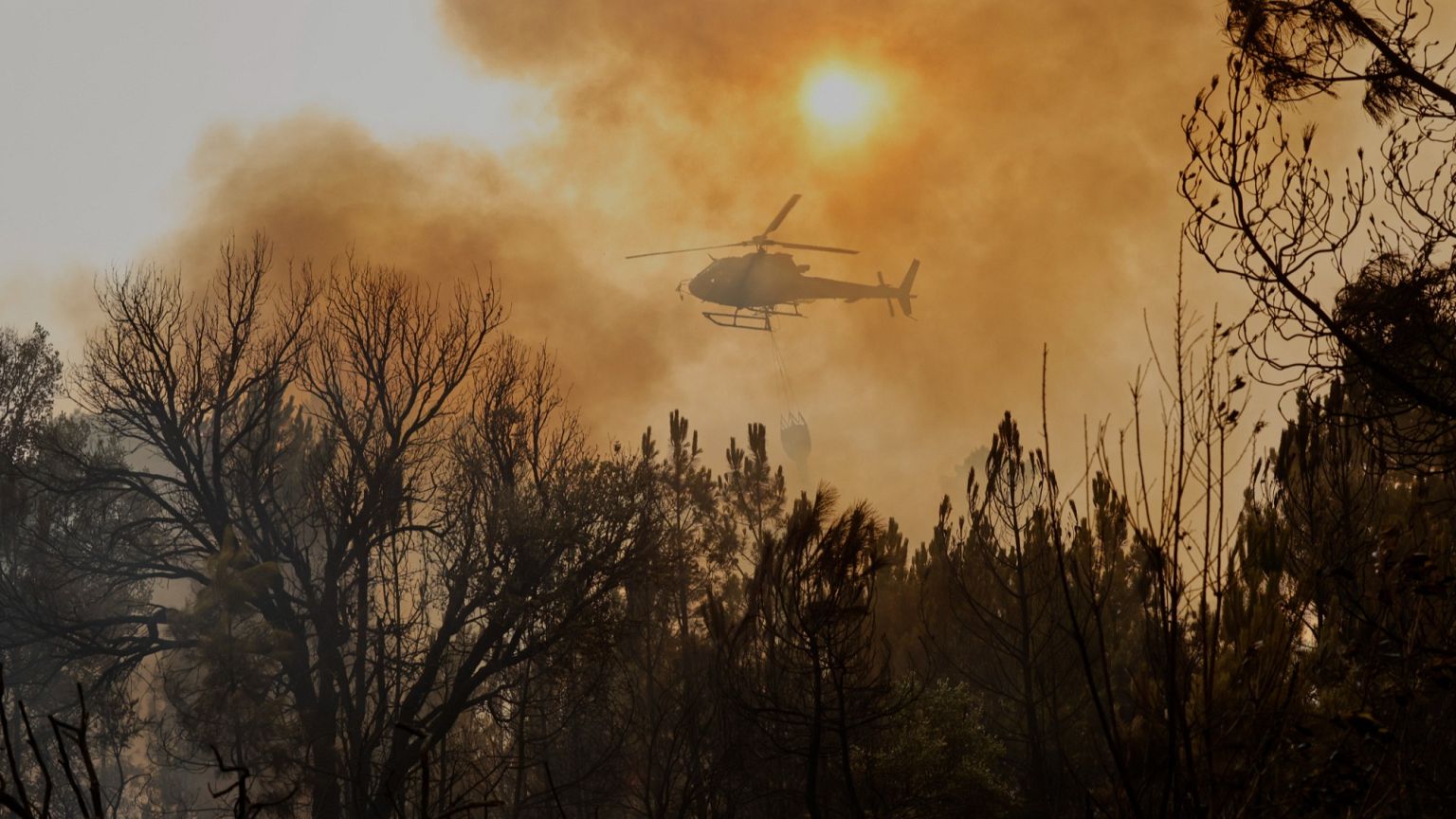 A helicopter drops water on a wildfire in Larouco, northwestern Spain, on 13 Aug, 2025.