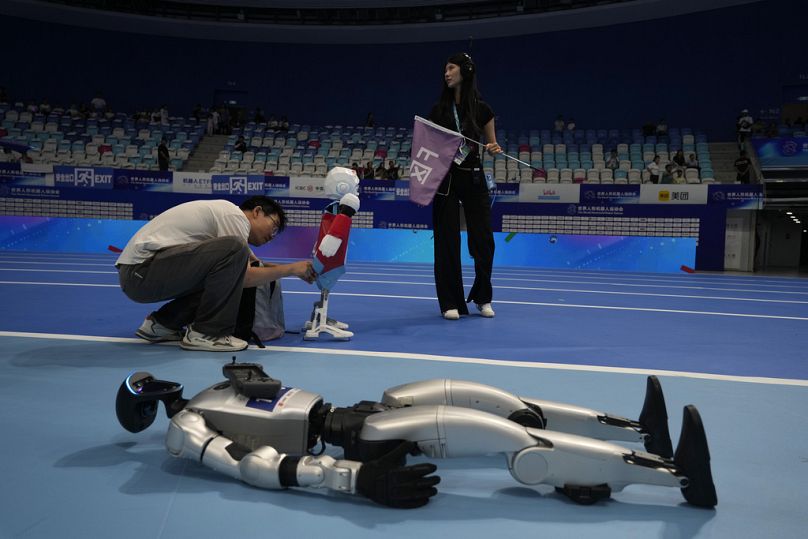 Açılış töreni öncesinde bir çalışan, robotların son hazırlığını tamamlarken, 14 Ağustos 2025