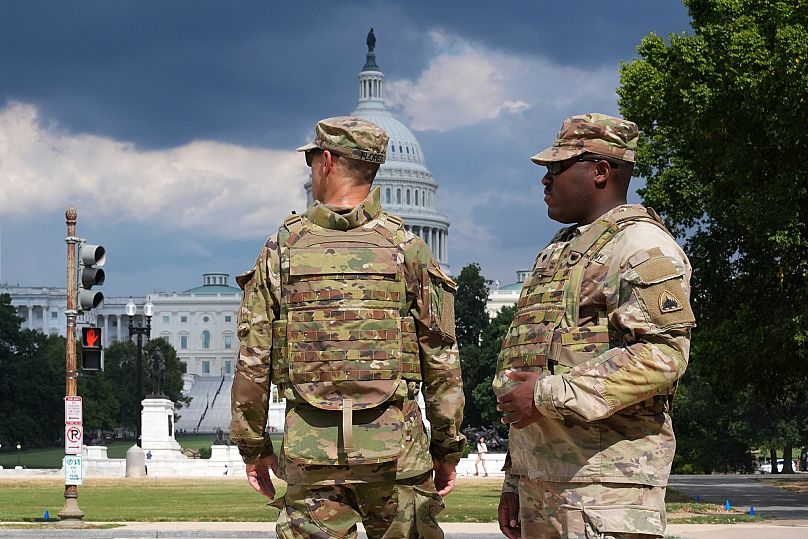 District of Columbia National Guard soldiers patrol on the National Mall, Thursday, August 14, 2025, in Washington. The U.S. Capitol is seen in the distance. (AP Photo/Jacquel