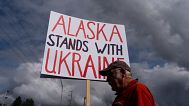 Dug Loshbaugh, ABD Başkanı Donald Trump ile Rusya Devlet Başkanı Vladimir Putin arasında yapılacak görüşme öncesinde, Perşembe günü Anchorage, Alaska'da düzenlenen bir mitingde pankart tutuyor, 14 Ağustos 2025