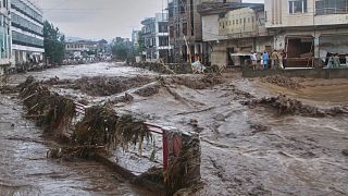 Local residents look at flash flooding due to heavy rains in a neighbourhood of Mingora, 15 August, 2025