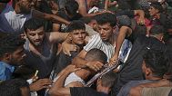 فلسطينيون يحاولون جمع مساعدات إنسانية أُسقطت بالمظلات فوق مدينة غزة، شمال القطاع، 14 أغسطس 2025.