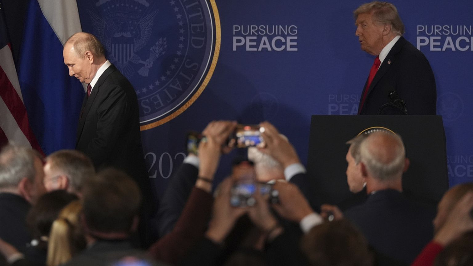 O Presidente Donald Trump, à direita, e o Presidente russo Vladimir Putin afastam-se após uma conferência de imprensa conjunta na Base Conjunta Elmendorf-Richardson, no Alasca