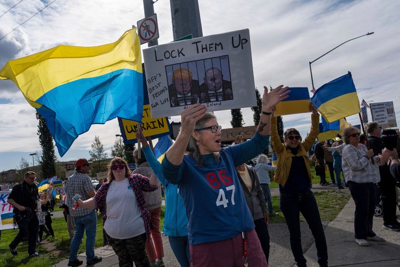 Demonstranten skandieren Parolen während einer Kundgebung in Anchorage, Alaska, am Donnerstag, dem 14. August 2025.