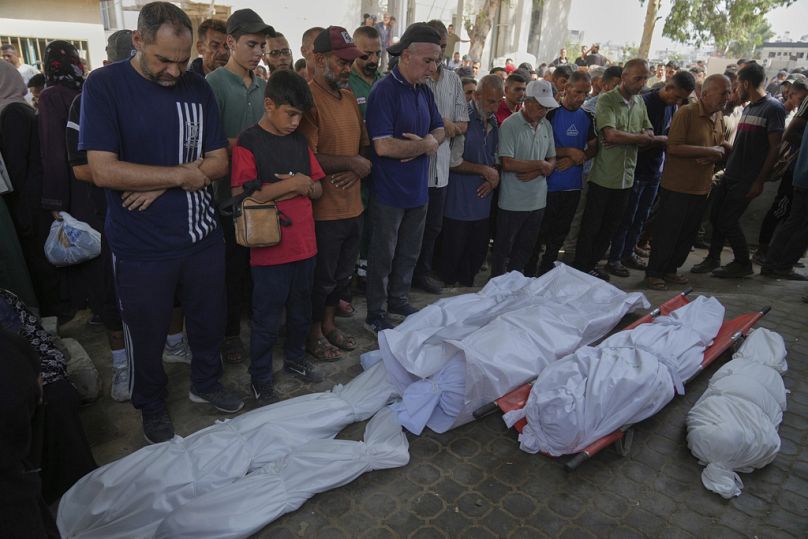  Palestinians pray over the bodies of people who were killed in Israeli airstrikes in Gaza City, Saturday, Aug. 16, 2025.