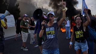 Demonstrators block a road during a protest demanding the immediate release of hostages held by Hamas near Jerusalem, Israel, Sunday, Aug. 17, 2025.