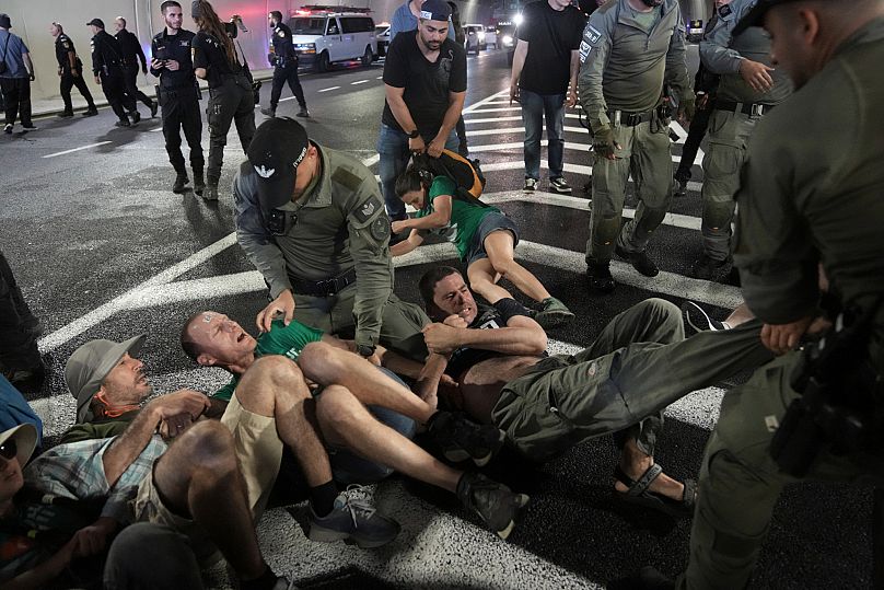 Police officers disperse demonstrators blocking a road during a protest demanding the immediate release of hostages held by Hamas in Jerusalem, Sunday, Aug. 17, 2025. 