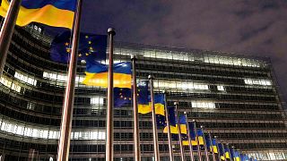 Flagi Unii Europejskiej i Ukrainy powiewają na wietrze z okazji trzeciej rocznicy pełnoskalowej inwazji Rosji na Ukrainę przed siedzibą UE w Brukseli.