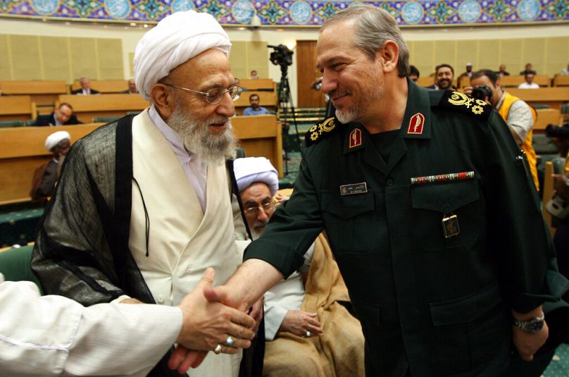 اللواء يحيى رحيم صفوي يصافح رجل دين خلال اجتماع في طهران عام 2007.