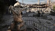 Κατεστραμμένα καταστήματα φαίνονται μπροστά από ένα άγαλμα μαχητή της Χεζμπολάχ σε εμπορικό δρόμο που επλήγη το βράδυ του Σαββάτου από ισραηλινές αεροπορικές επιδρομές στο νότιο Λίβανο, 13 Οκτωβρίου, 2024