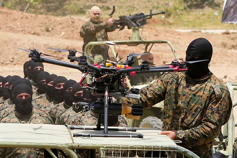 A Hezbollah fighter stands next to an armed drone during a training exercise in Aaramta village in southern Lebanon, 21 May, 2023