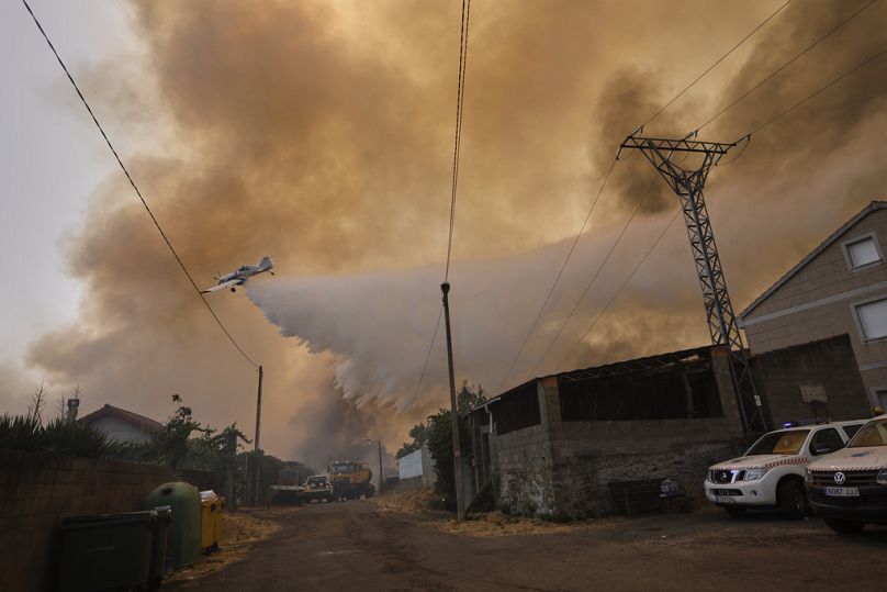 Un aereo antincendio scarica acqua su un incendio boschivo a Veiga das Meas, nel nord-ovest della Spagna, 16 agosto 2025