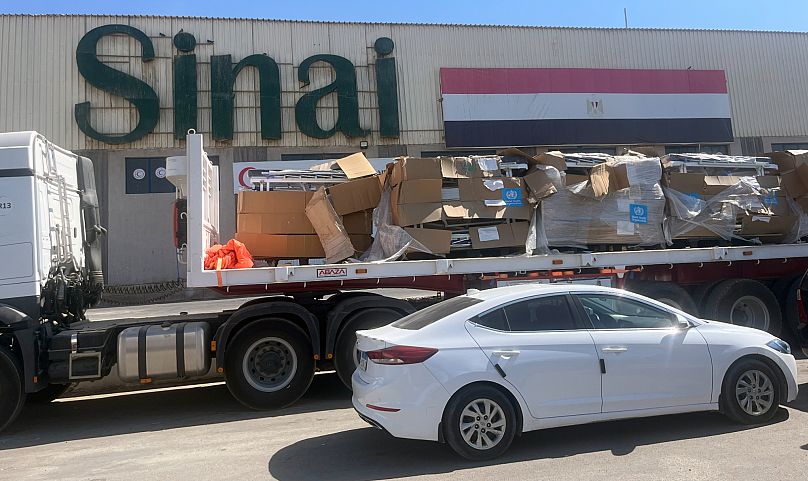 Une voiture est garée à côté d'un camion d'aide humanitaire au poste-frontière de Rafah en Égypte, le 18 août 2025