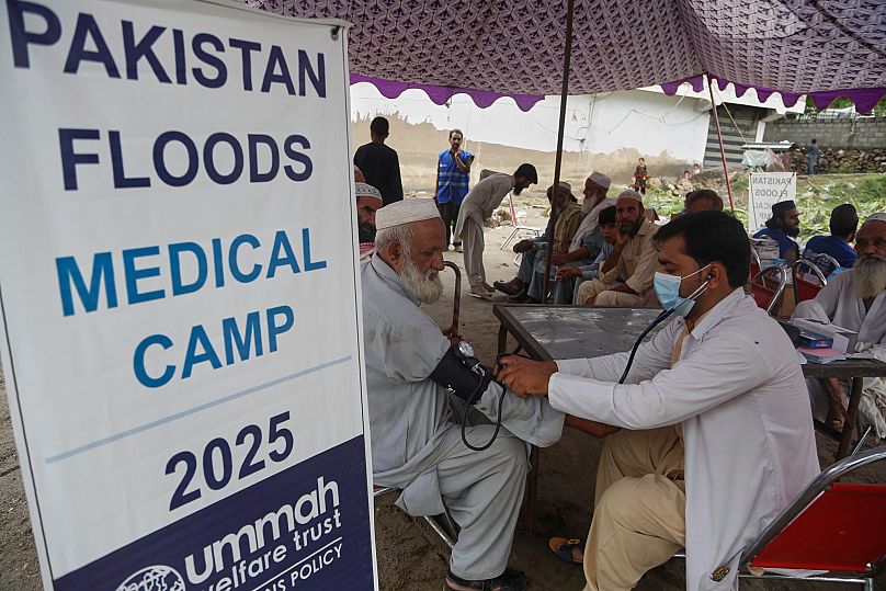 A doctor checks local residents at a medical camp set up by volunteers for victims of the flash flooding in Buner district, 17 August, 2025