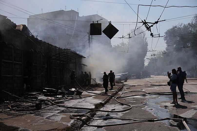 Les secouristes éteignent un incendie dans des magasins commerciaux détruits par une attaque de missiles russes à Zaporijjia, le 18 août 2025.