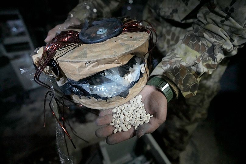 A Syrian rebel shows Captagon pills hidden in an electrical component at a warehouse in Douma, 13 December, 2024
