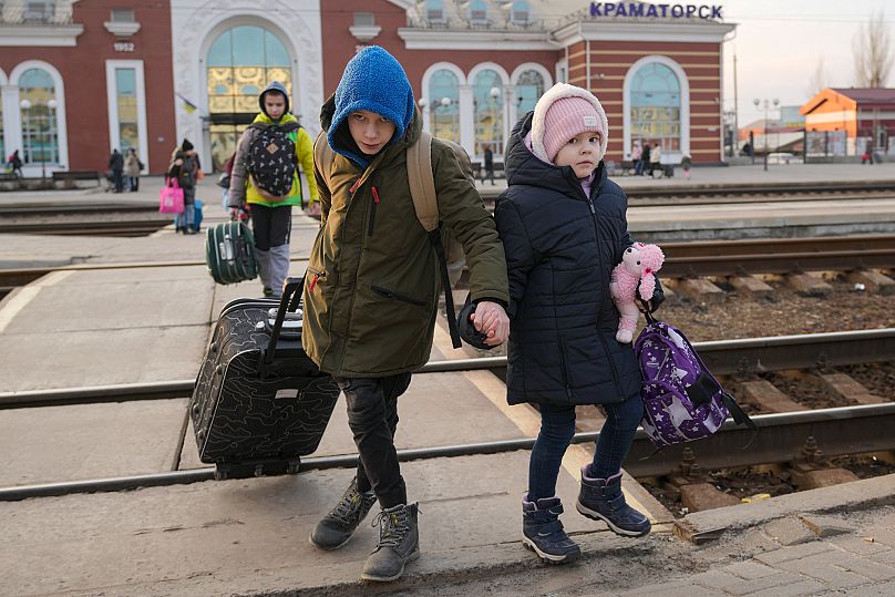 Children hold hands as they arrive to board a Kyiv bound train in Kramatorsk, 24 February, 2022