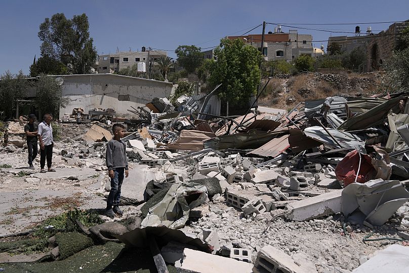 Palästinenser bei ihrem von Israel zerstörten Haus in Beit Sira bei Ramallah,  19. August 2025.