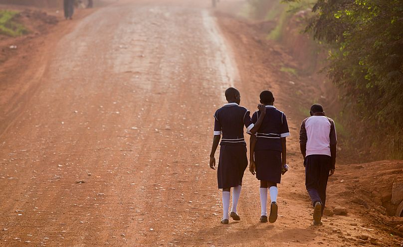 Ugandan children walk along a road to school in Kasangati, 22 February, 2016