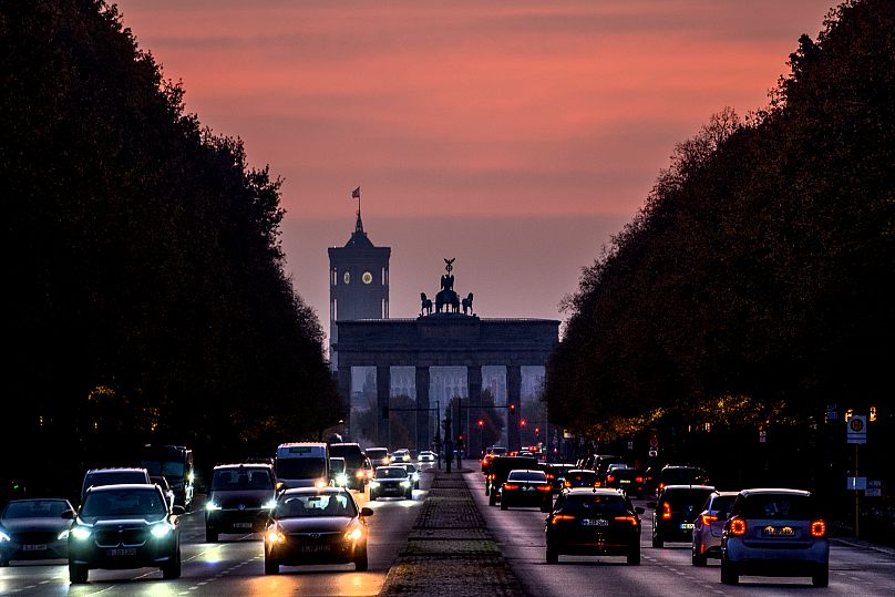 Il traffico scorre davanti alla Porta di Brandeburgo e al municipio di Berlino, 18 ottobre 2024