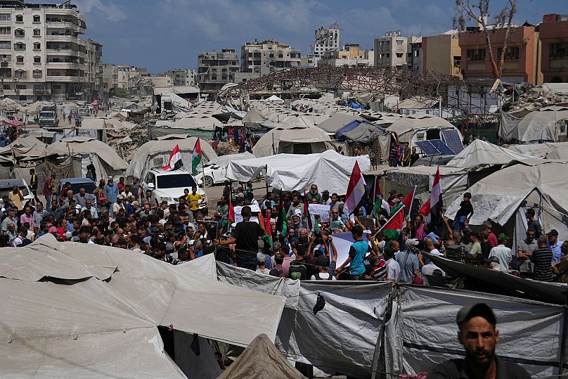 Palestinians take part in a protest calling for the end of the war in the Gaza Strip as they gather at a tent camp for displaced people, in Gaza City, Thursday, Aug, 21, 2025.