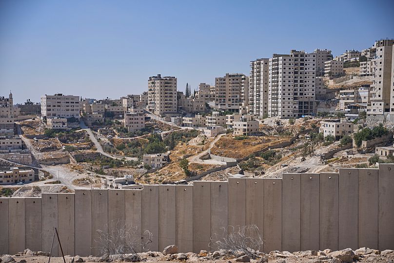 The separation wall next to the Arab neighborhood of Al-Eizariya near where the Israeli government says housing units will be built as part of the E1 project, 21 August, 2025
