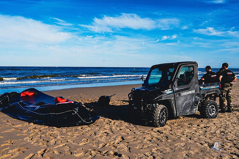 Des policiers se tiennent près d'un canot pneumatique échoué sur la plage d'Ecault, dans le nord de la France, le vendredi 4 juillet 2025