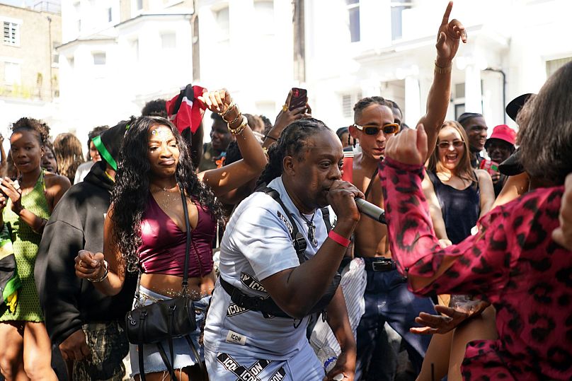 MC means move the crowd as people sing and dance at Notting Hill carnival 