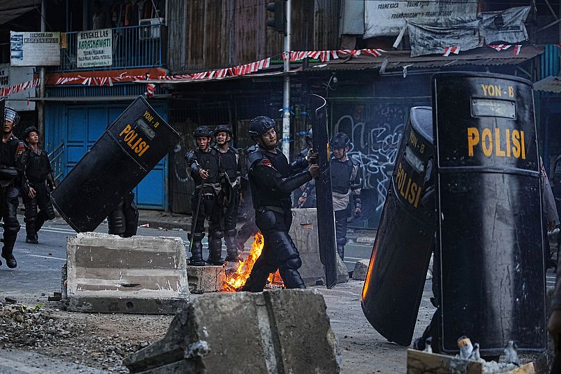 Riot police officers carry shields as they take position during a protest against lavish allowances given to parliament members in Jakarta, 25 August, 2025
