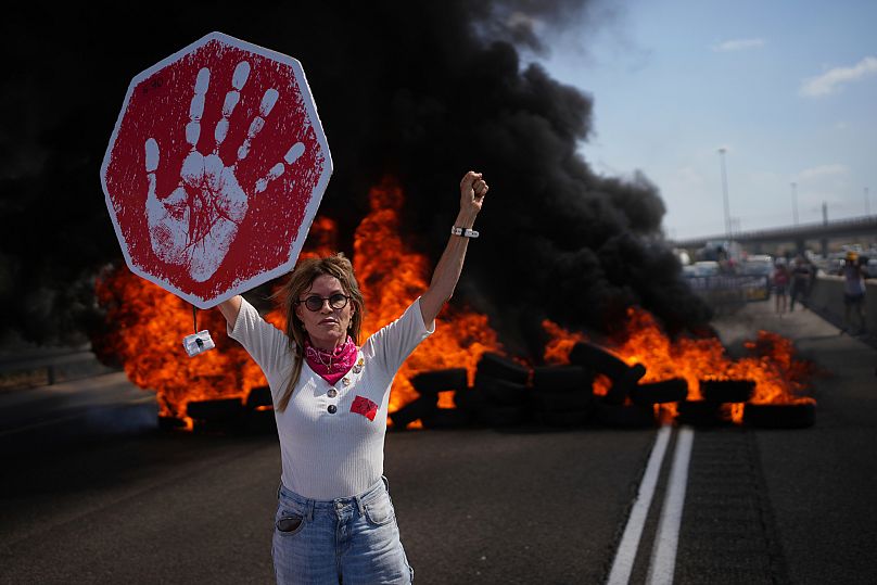 A demonstrator blocks a highway during a protest demanding the immediate release of all hostages held by Hamas near Modiin, 26 August, 2025